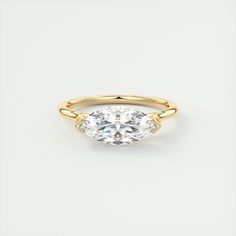 a yellow gold ring with a pear shaped diamond