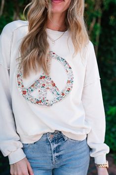 We all love a good pullover and this one is so fun! This taupe pullover features a peace sign with dainty florals. This pullover features distressed edging throughout the shoulders and arm. This lightweight fabric is a great transition piece for the spring time. The Fabric: 100% Cotton Product Details: Sizing runs true. Lightweight long sleeve Model is shown wearing a Small. Spring Distressed Cotton Sweatshirt, Spring Cotton Distressed Sweatshirt, Hippie Crew Neck Top For Fall, Distressed Long Sleeve Sweater For Spring, Spring Crew Neck Soft-washed Sweater, Soft-washed Crew Neck Sweater For Spring, Spring Bohemian Cotton Sweatshirt, Soft-washed Sweater For Spring Loungewear, Spring Soft-washed Sweater For Loungewear