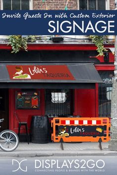 a bike parked in front of a red building with signage on the door and windows