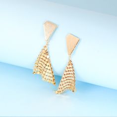 These geometric gold plated earrings will add instant sparkle and shine to any outfit. The handkerchief-inspired dangle design creates movement when you walk, catching the light in a unique way. The triangle stud backs ensure they'll stay put all night long, through dancing, laughing and all the festivities. Perfect party earrings for fashion-forward gals seeking a statement accessory that stands out from the crowd. Materials: 24k gold plated brassDimensions: 2.61 x 0.92 in Jewelry Care: See more information about how to care for your jewelry here. Shipping Policy: Orders will be shipped within 1-3 business days. Economy shipping will take 7-14 days to arrive and standard shipping is 1- 4 days for U.S. orders. International shipping time is depended on the country and per shipping method. Trendy Gold Chandelier Earrings For Evening, Gold-plated Teardrop Earrings For Party, Trendy Gold Triangle Earrings, Diamond-shaped Gold Jewelry For Party, Gold Diamond-shaped Party Jewelry, Triangle Gold Metal Earrings, Gold Triangle Metal Earrings, Gold Teardrop Dangle Earrings For Party, Chic Gold Teardrop Earrings For Party