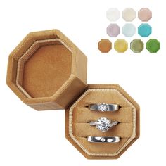 an open ring box with three rings in it and four different colors on the inside