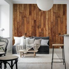 a living room with wood paneling on the wall and furniture in front of it