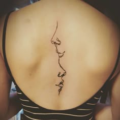 a woman's back with a vine tattoo on it