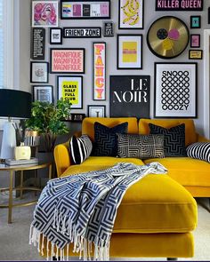 a living room filled with yellow couches and pictures on the wall above it's headboard