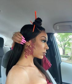 a woman sitting in the back seat of a car with tattoos on her face and neck