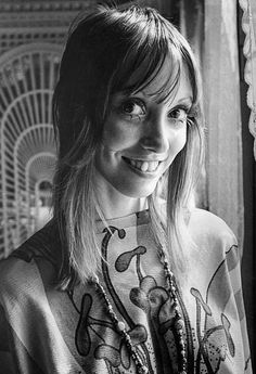 a black and white photo of a woman with long hair wearing a shirt that has flowers on it