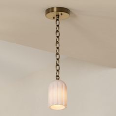 a light fixture hanging from the ceiling in a room with white walls and flooring