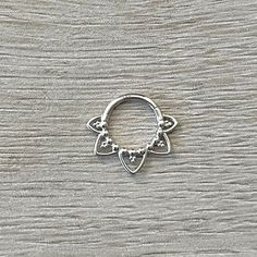 a small silver ring sitting on top of a wooden table