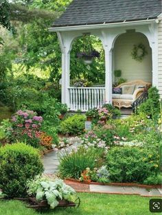 an outdoor gazebo surrounded by flowers and plants