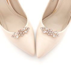 a pair of white high heel shoes with crystal accents