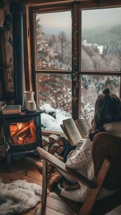 a woman sitting in a chair reading a book next to an open fire place on the floor