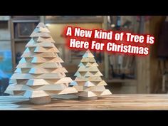 three wooden christmas trees on a table with the words a new kind of tree is here for christmas