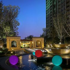 an outdoor fountain with colorful balls in the water