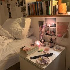 a bedroom with books, candles and other items on the table