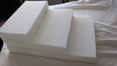 three pieces of white foam sitting on top of a bed