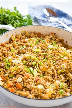 a pan filled with rice and vegetables on top of a table