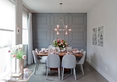 a dining room table is set with flowers and place settings for four people to eat