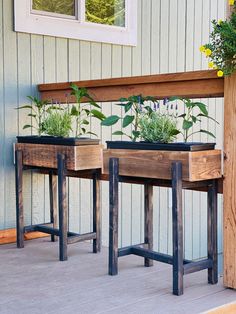 two wooden planters with plants in them on a porch