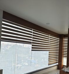 a bedroom with large windows and blinds in it