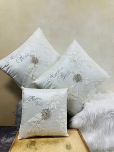 three white pillows sitting on top of a wooden table