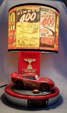 a lamp that is sitting on top of a table next to a remote control car