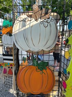 pumpkins and gourds are on display in a cage