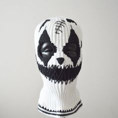 a white and black knitted panda face mask