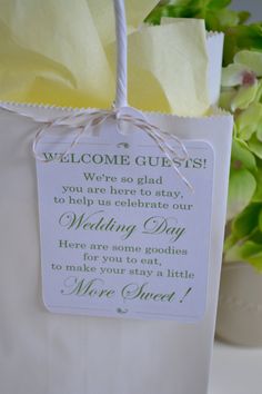 a white bag with a welcome guest tag attached to it and flowers in the background