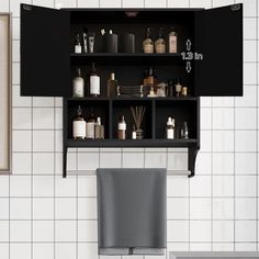 a bathroom with black cabinets and white tiles on the wall, including a gray chair