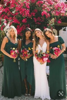 bridesmaids in green dresses with red and yellow bouquets posing for the camera