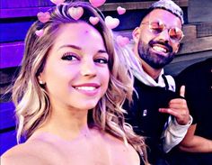 two men and a woman posing for a photo with hearts on their foreheads in front of them