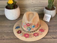 This beautiful Mexican Sombrero has beautiful hand painted flowers, perfect to add that special touch to any outfit. The hat itself is made out of jute material and is very light and breathable. Bohemian Hand Painted Panama Hat With Flat Brim, Bohemian Wide Brim Hand Painted Panama Hat, Bohemian Hand Painted Wide Brim Panama Hat, Bohemian Multicolor Hat Bands For Spring, Artisan Fedora For Spring Country Events, Adjustable Hand Painted Bohemian Panama Hat, Bohemian Adjustable Hand Painted Panama Hat, Adjustable Bohemian Hand Painted Panama Hat, Handmade Multicolor Panama Hat For Spring