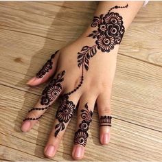 a woman's hand with henna tattoos on it