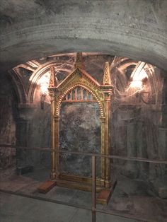 an ornate mirror in the middle of a stone tunnel with light coming from it's windows