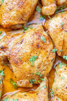 closeup of chicken thighs in a yellow sauce with parsley on the top and bottom