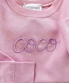 a pink shirt with the word coco embroidered on it