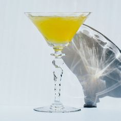 a glass filled with yellow liquid sitting on top of a table