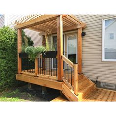 a wooden deck with planters on it next to a house