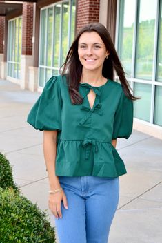 Bow tie front puff sleeve peplum blouse, pullover, V neckline Available in black, ecru and hunter green Sizes S, M and L Fabric: 100% polyester Fall Puff Sleeve Top For Day Out, Casual Blouse With Puff Tie Sleeves, Brunch Puff Sleeve Top With Balloon Sleeves, Chic Green Tops With Gathered Sleeves, Chic Green Top With Gathered Sleeves, Spring V-neck Top With Bow, Spring V-neck Top With Bow Detail, Fall Blouse With Gathered Sleeves For Day Out, Chic Green Puff Sleeve Top