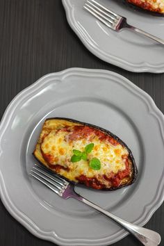 an eggplant stuffed with cheese on two plates