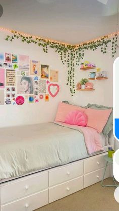 a bedroom with white walls and lots of pictures hanging on the wall above the bed