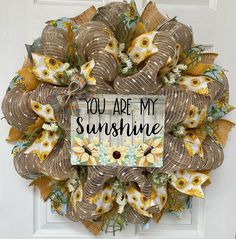 a sunflower wreath with the words you are my sunshine written on it in front of a door