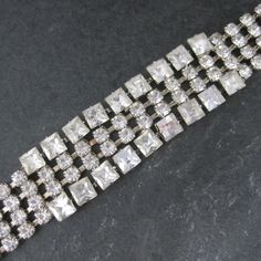 This beautiful 50s era rhinestone bracelet features a box clasp with safety chain. Measurements: 7/8 of an inch at its widest - 6 3/4 wearable inches Marks: None Condition: Excellent with original retail store box - Possibly old new stock  NOTE: The box definitely smells old due to being in storage since at least the 60s. Vintage Tennis Bracelet For Wedding, Vintage Crystal Bracelets For Formal Occasions, Vintage Crystal Bracelets For Evening, Vintage Crystal Bracelet With Sparkling Stones For Formal Occasions, Formal Vintage Crystal Bracelet With Sparkling Stones, Vintage Rhinestone Crystal Bracelet For Party, Vintage Bracelets With Sparkling Stones For Formal Occasions, Vintage Formal Bracelets With Sparkling Stones, Classic Crystal Bracelet With Sparkling Stones For Party