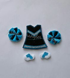 two blue and white hair clips, one with a cheerleader dress on it's side