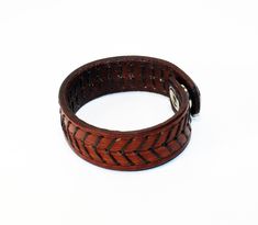 a close up of a leather bracelet on a white background