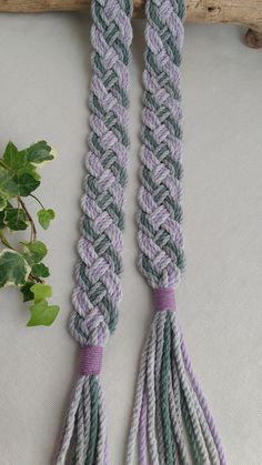 two purple and green tassels on a white surface