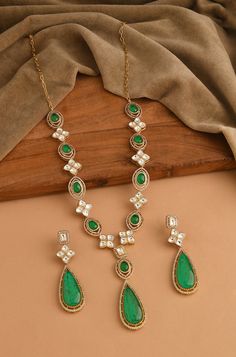 This modern interpretation of late Victorian art is a masterpiece of elegance and charm. Adorned with intricately cut polkis, cubic zirconia, and mint green crystals, this Necklace Set captures the essence of the period's glory while adding a touch of finery and glamour to any outfit Finish: 22KT Gold Plating Material: Silver, Copper Alloy, Polki Color: Mint Size: Free Size, Adjustable Closure Type: Lobster Box Contains: 1 Necklace, 1 Pair Earrings Elegant Emerald Kundan Necklace With Stone Work, Elegant Kundan Necklace With Emerald Stone Work, Elegant Emerald Necklace With Stone Work As Gift, Elegant Emerald Jewelry With Stone Work, Elegant Emerald Necklace With Stone Work, Exquisite Hand Set Green Bridal Necklace, Elegant Green Emerald Necklace With Stone Work, Elegant Green Kundan Emerald Necklace, Elegant Green Jewelry With Stone Work