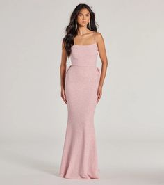 a woman in a pink gown posing for the camera with her hands on her hips