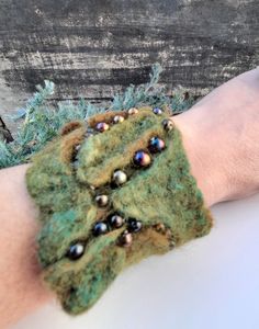 a person's arm with a green and black bracelet that has beads on it