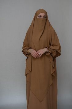 Introducing the Avalom Prayer Gown Umrah Abaya Dress in Brown by Annah Hariri, the perfect addition to your modest wardrobe. This elegant one-piece abaya dress is made from non-wrinkling fabric, ensuring that you always look put-together without the hassle of ironing.Featuring a classic A-cut design, this abaya dress offers ample coverage, making it suitable for any prayer occasion. It also comes with pockets, making it functional and convenient for carrying your essentials. The beautiful sleeve Umrah Abaya, Annah Hariri, Modest Wardrobe, Abaya Dress, Maxi Dress With Sleeves, Layers Design, Cut Design, Modest Fashion, Carry On